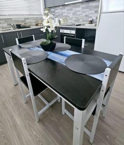 a kitchen table with two chairs and a black and white table at San Remo Coastal Apartment in San Remo