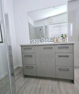 a bathroom with a sink and a large mirror at San Remo Coastal Apartment in San Remo