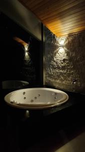 Łazienka z umywalką w ciemnym pokoju w obiekcie CABANAS LE VIGNE w mieście Pinto Bandeira