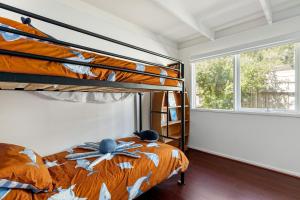 a bedroom with two bunk beds and a window at Rosebud Hideaway - Cute Contemporary by the Beach in Rosebud