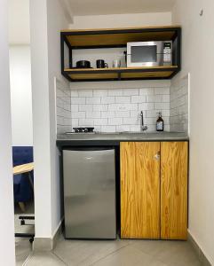 een keuken met een wastafel en een magnetron bij Casa hotel Los Laureles in Medellín