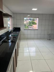a kitchen with black counter tops and a window at Espaço Santos Neves in Ribeirão das Neves