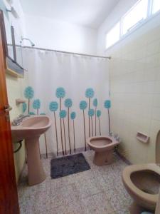 baño con 2 aseos y cortina de ducha con árboles en Casa a tres cuadras del mar, en Puerto Madryn