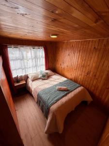 a small room with a bed in a cabin at Hostal Magia Chilota in Castro