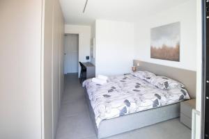 een witte slaapkamer met een bed en een bureau bij Argento Spectacular and Modern 5 for 4 guests -By EasyLife Swiss in Bellinzona