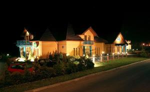 una casa grande con luces en el lateral de una calle en Hotel U Milína, en Milín