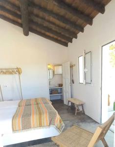 ein Schlafzimmer mit einem Bett, einem Tisch und einem Stuhl in der Unterkunft Fonte Freixo, em Borba, Alentejo in Borba
