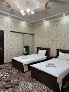 - une chambre avec 2 lits et un lustre dans l'établissement VOSTOK HOTEL, à Boukhara