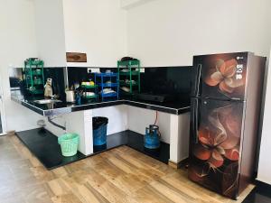 een keuken met een zwart aanrecht en een koelkast bij Little Paradise in Weligama