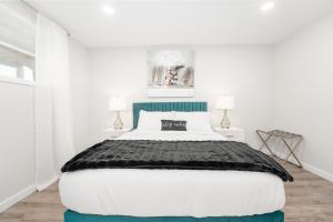 a bedroom with a large bed and two lamps at Cozy Retreat with Hot Tub and Free Breakfast! in Lethbridge