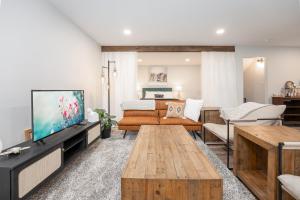 ein Wohnzimmer mit einem Sofa und einem TV in der Unterkunft Cozy Retreat with Hot Tub and Free Breakfast! in Lethbridge