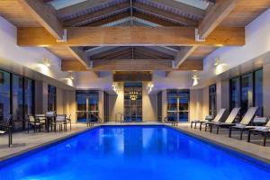 a pool in a hotel with chairs and tables at Sheraton Hartford South in Rocky Hill