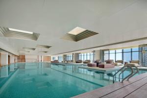 a large swimming pool in a building with windows at Liyang Marriott Hotel in Liyang