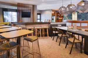 a restaurant with tables and chairs and a bar at SpringHill Suites by Marriott Corona Riverside in Corona