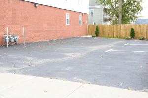 a parking lot next to a red brick building at 4 bedroom short term rental furnished Apt in Schenectady