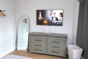 a bedroom with a dresser with a tv on the wall at 4 bedroom short term rental furnished Apt in Schenectady