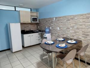 una cucina con un tavolo e sedie in una stanza di Atlântico Flat - Pé na Areia em Ponta Negra -114 a Natal