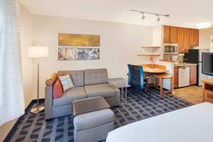 a living room with a couch and a kitchen at TownePlace Suites by Marriott Bentonville Rogers in Bentonville