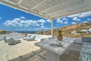 a patio with a table and chairs and a view of the ocean at Senses Luxury Villas & Suites in Elia Beach
