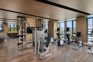 a gym with several exercise equipment in a room with windows at Courtyard by Marriott Nanjing Jiangning in Nanjing