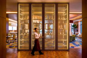 Un hombre pasa junto a una gran pared de jaulas de pájaros. en The Sandalwood Beijing Marriott Executive Apartments, en Beijing 73 fotos más