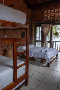 a bedroom with two bunk beds and a window at Hotel Katamaran in Capurganá