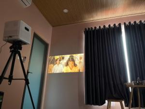 una telecamera su un treppiede in una stanza con tenda di Homestay Mina House a Long Xuyen