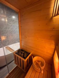 a sauna with a tub and a basket of rocks at Homestay Mina House in Long Xuyên