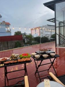 two tables with food on top of a balcony at Homestay Mina House in Long Xuyên