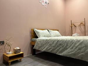 a bedroom with a bed and a side table at Homestay Mina House in Long Xuyên