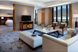 uma sala de estar com um sofá e uma sala com uma televisão em Wutai Mountain Marriott Hotel em Wutai