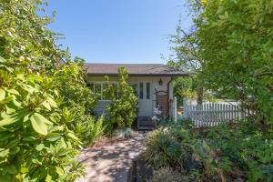 een klein wit huis met een poort en een tuin bij SQ Rose Bud 1 in Sequim