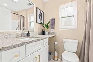 a white bathroom with a sink and a toilet at New! Cozy 1BR minutes from Downtown Roseville in Roseville