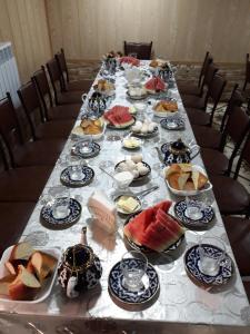 een lange tafel met borden eten erop bij Hello Hostel in Samarkand