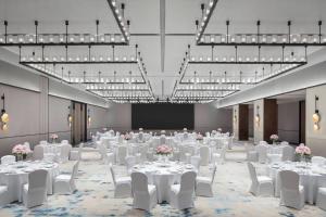 a banquet hall with white tables and chairs and lights at Courtyard Taiyuan in Taiyuan
