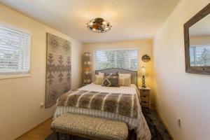 a bedroom with a bed and a chandelier at Sq Wild Rose 2 in Sequim