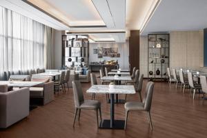 a restaurant with tables and chairs in a room at Shanghai Marriott Hotel Kangqiao in Shanghai