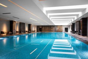 uma grande piscina com cadeiras num edifício em Shanghai Marriott Hotel Kangqiao em Xangai