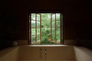 uma banheira com uma janela na casa de banho em Uon em Gyeongju