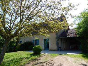 una casa blanca con un árbol en el patio en Gîte Le Brethon, 3 pièces, 4 personnes - FR-1-489-238, en Le Brethon