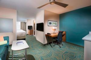a hotel room with a desk and a bed at SpringHill Suites by Marriott Atlanta Alpharetta in Alpharetta