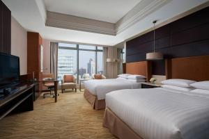 a hotel room with two beds and a flat screen tv at Shanghai Marriott Hotel Riverside in Shanghai