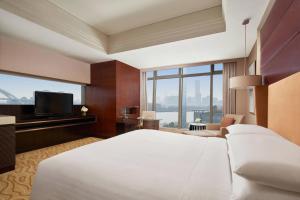 a hotel room with a large bed and a large window at Shanghai Marriott Hotel Riverside in Shanghai