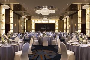 a banquet hall with tables and chairs and a screen at Renaissance Shanghai Putuo Hotel in Shanghai