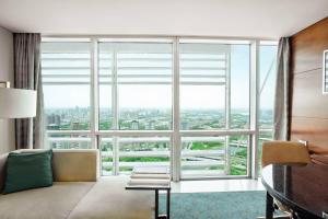 Habitación con ventana grande, sofá y escritorio. en JW Marriott Hotel Zhengzhou en Zhengzhou