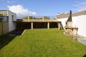 a grassy yard next to a building with a bridge at 4 bedrooms house with sea view enclosed garden and wifi at Cambados Pontevedra 1 km away from the beach in Cambados
