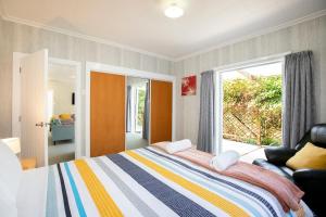 a bedroom with a bed and a large window at Cliffscapes in Punakaiki