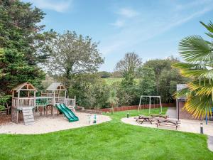um quintal com um parque infantil com um escorrega em Villa Gallery - 27074 em Perranwell