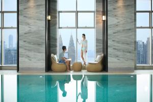 duas pessoas sentadas em cadeiras num quarto com uma janela em Chongqing Marriott Hotel em Chongqing