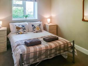 a bedroom with a bed with two bags on it at Swallows Way in Briston